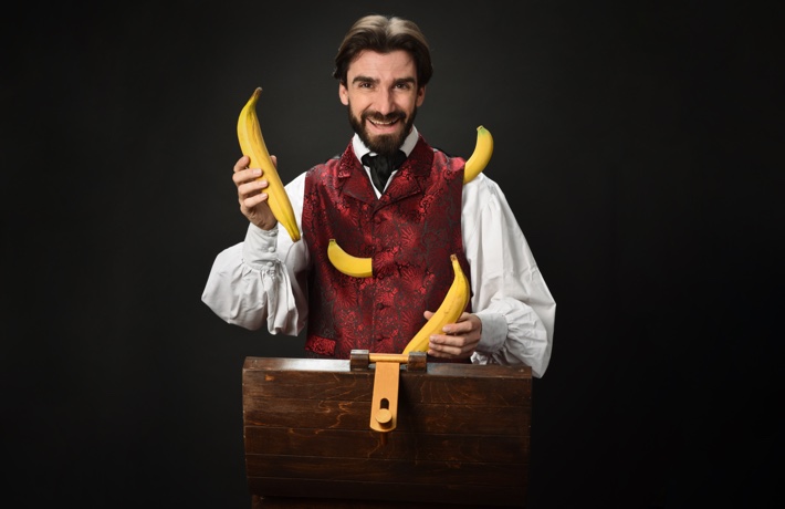 Benoît Rosemontjongle tient des bananes dans les mains, alors que deux sortent de sa veste.
