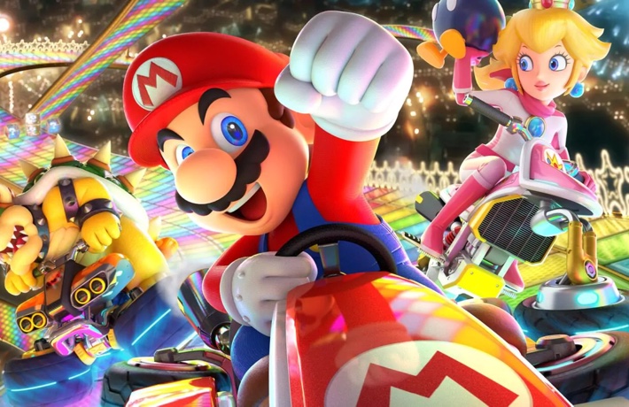 Illustration du jeu Mario Kart avec Mario, Daisy et Bowser dans leur bolide faisant la course sur la piste arc-en-ciel.