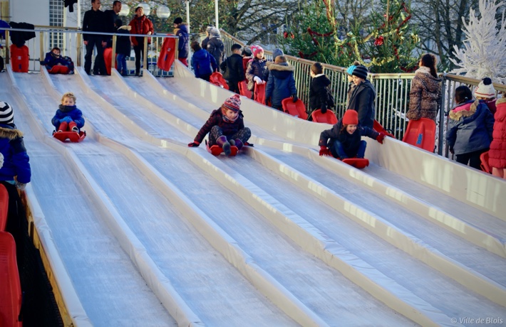Des enfants dévalent les pistes sur une luge.